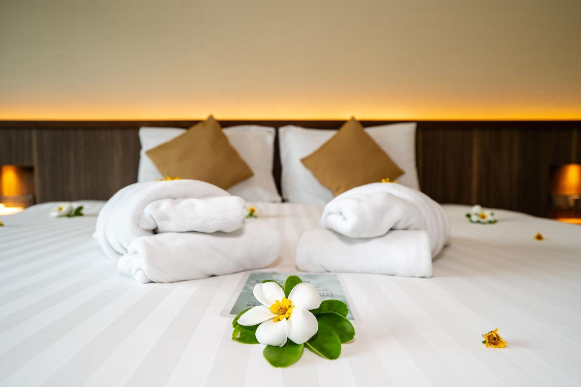 Le Resort And Villas Rawai Eksteriør bilde A bed with towels and flowers